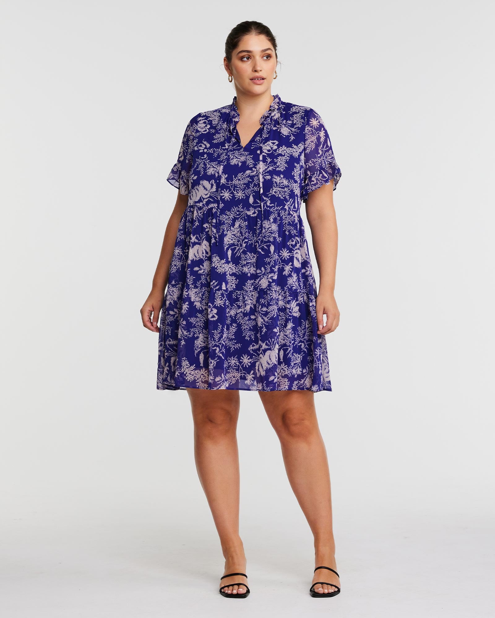 A plus size woman wearing the Estelle Ultra Leaf Purple Tiered Knee Length Dress.