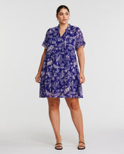 A plus size woman wearing the Estelle Ultra Leaf Purple Tiered Knee Length Dress.