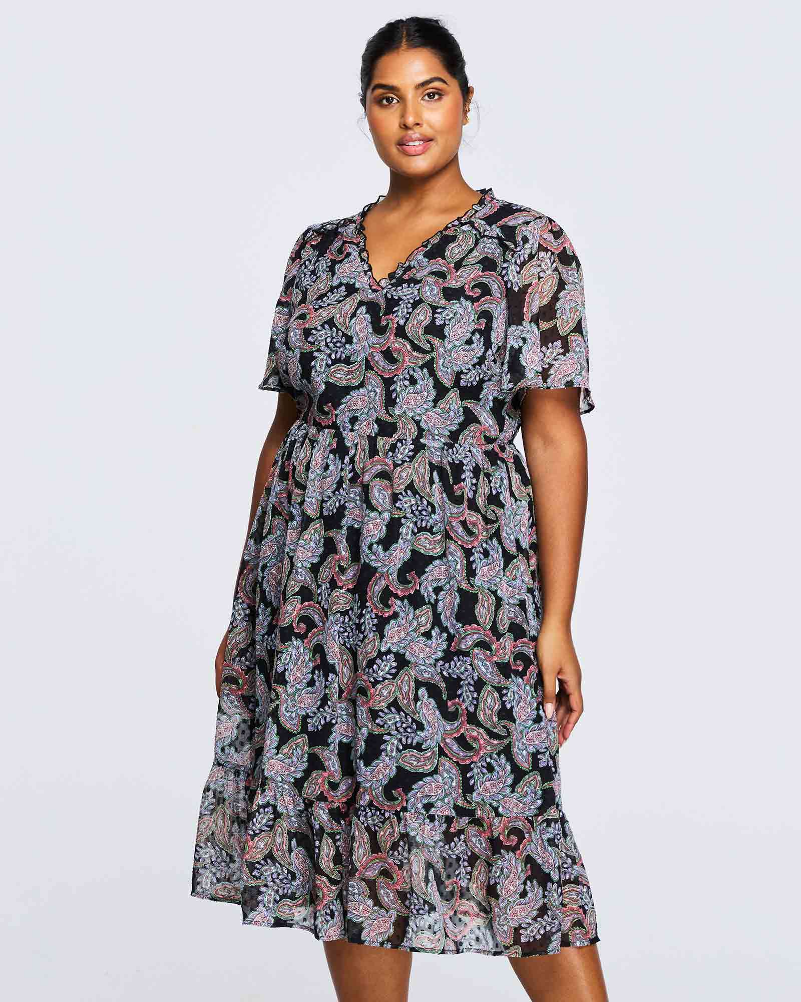 A plus size woman wearing an Estelle Maya Purple Paisley Midi Dress.
