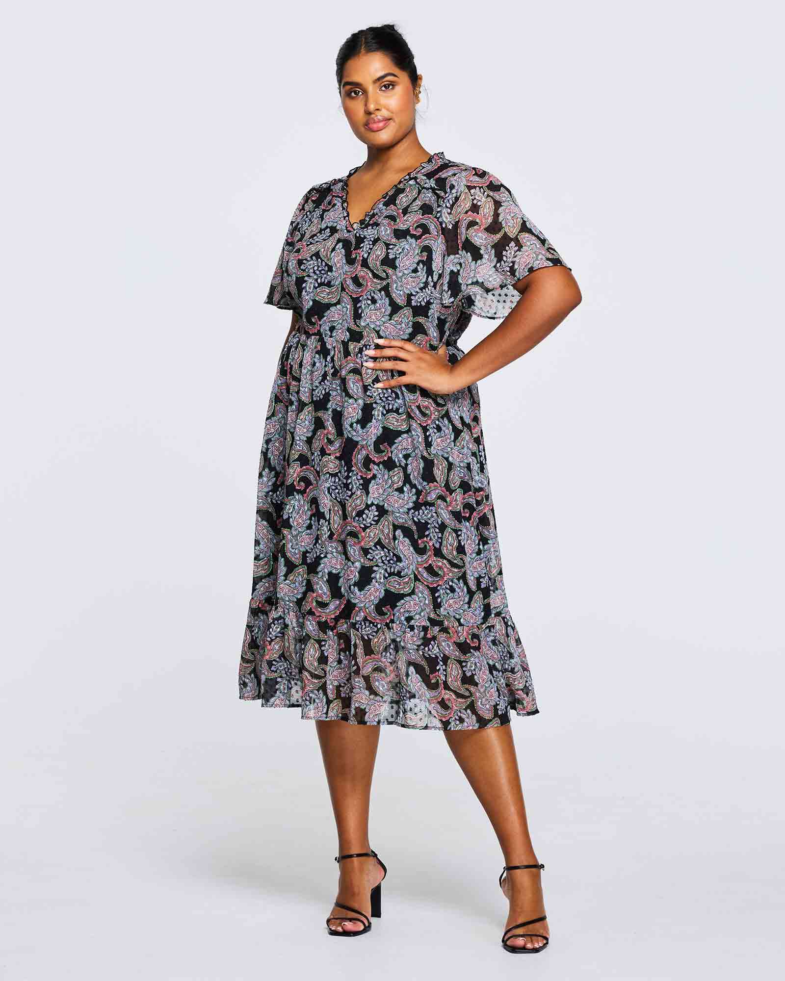 A plus size woman wearing an Estelle Maya Purple Paisley Midi Dress.