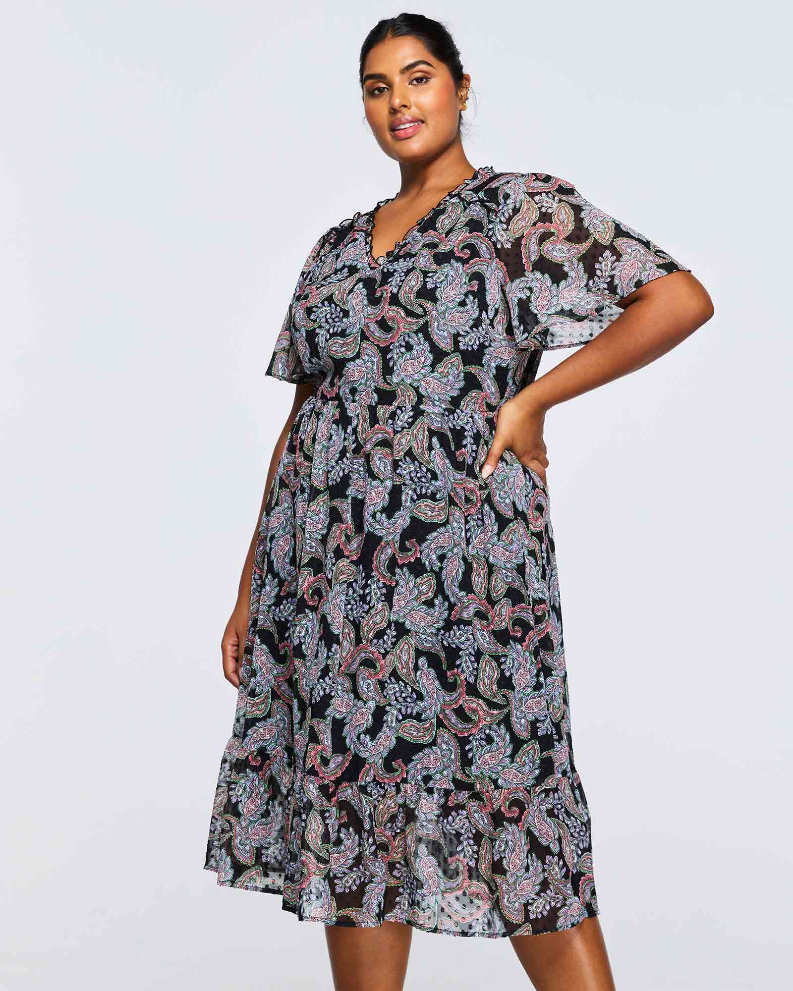 A plus size woman wearing an Estelle Maya Purple Paisley Midi Dress.