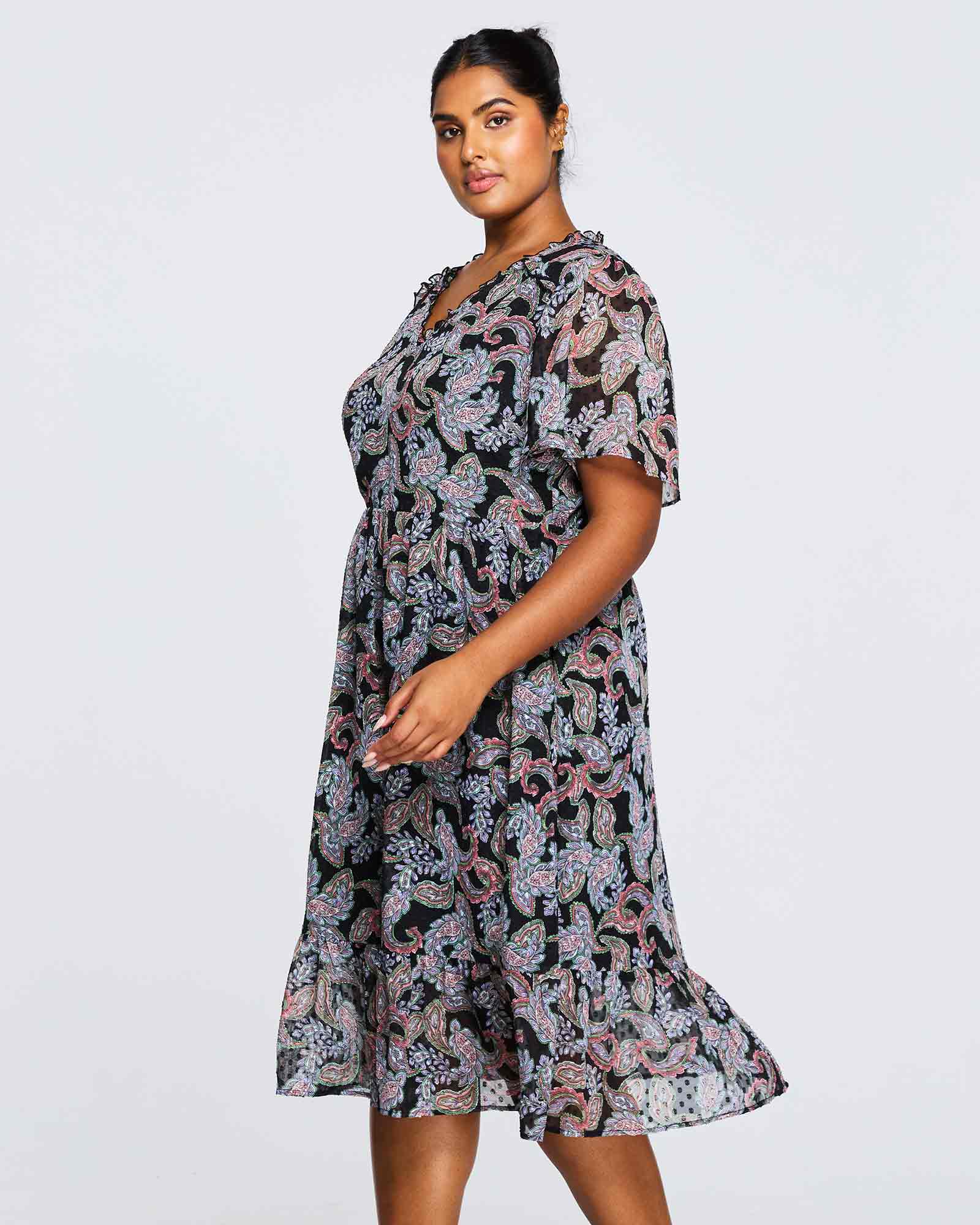 A plus size woman wearing the Estelle Maya Purple Paisley Midi Dress.