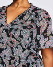 A woman wearing an Estelle Maya Purple Paisley Midi Dress.