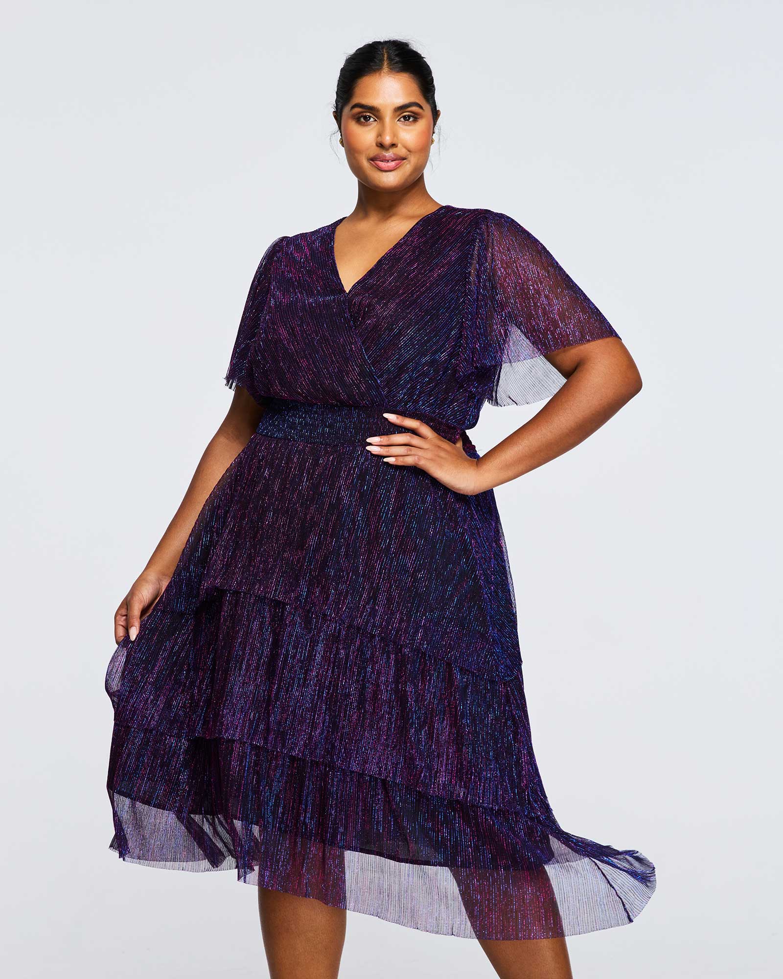 A plus size woman is posing in the Glitterland Metallic Sparkly Midi Dress.
