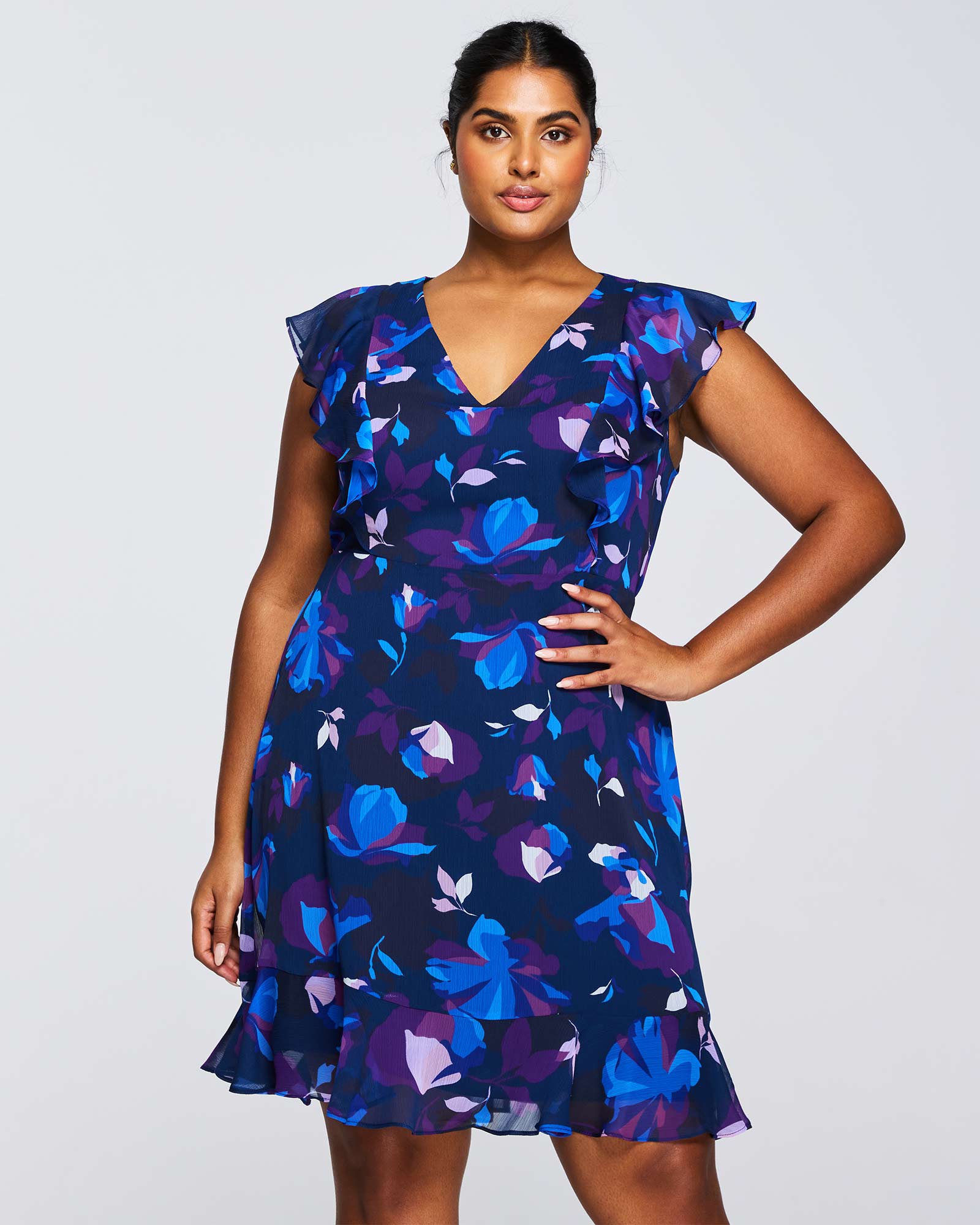 A plus size woman wearing an Estelle Midnight Blue Blossom Knee Length Dress.