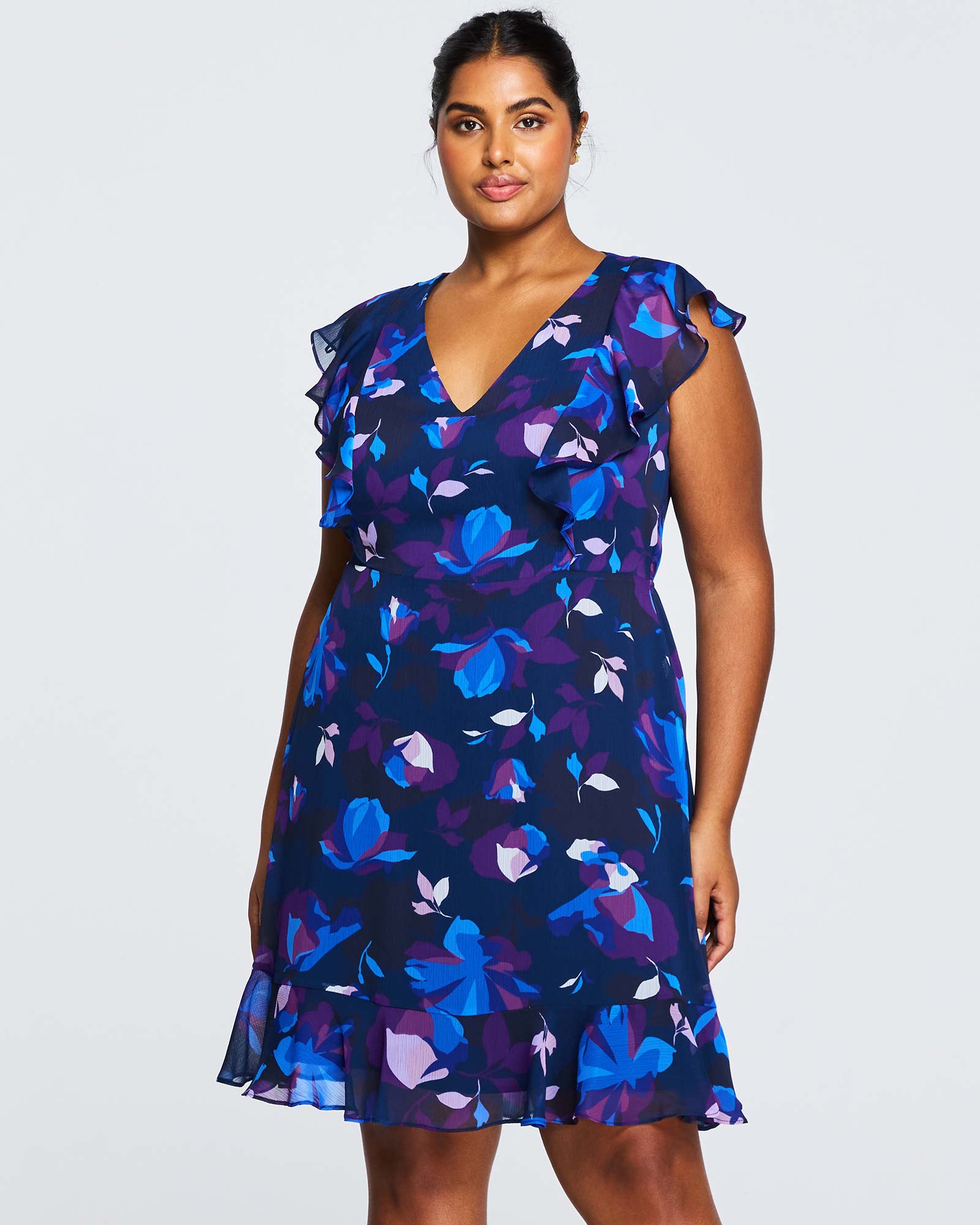 A plus size woman wearing a Estelle Midnight Blue Blossom Knee Length Dress.