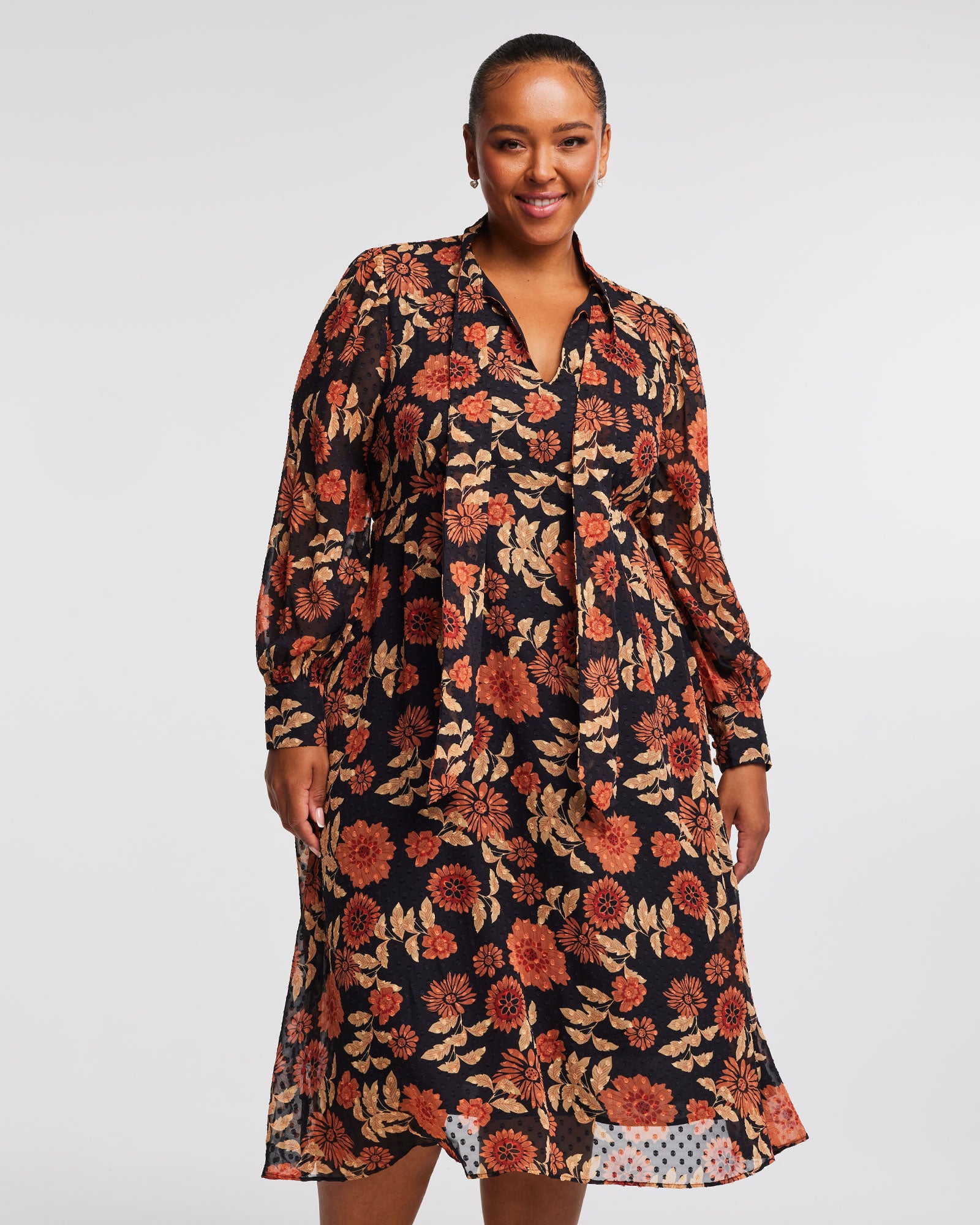 A plus size woman wearing an Autumnal Floral Midi Dress with Neck-Tie.