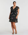 An Estelle plus size woman wearing a Climbing Rose Black Mini Dress.