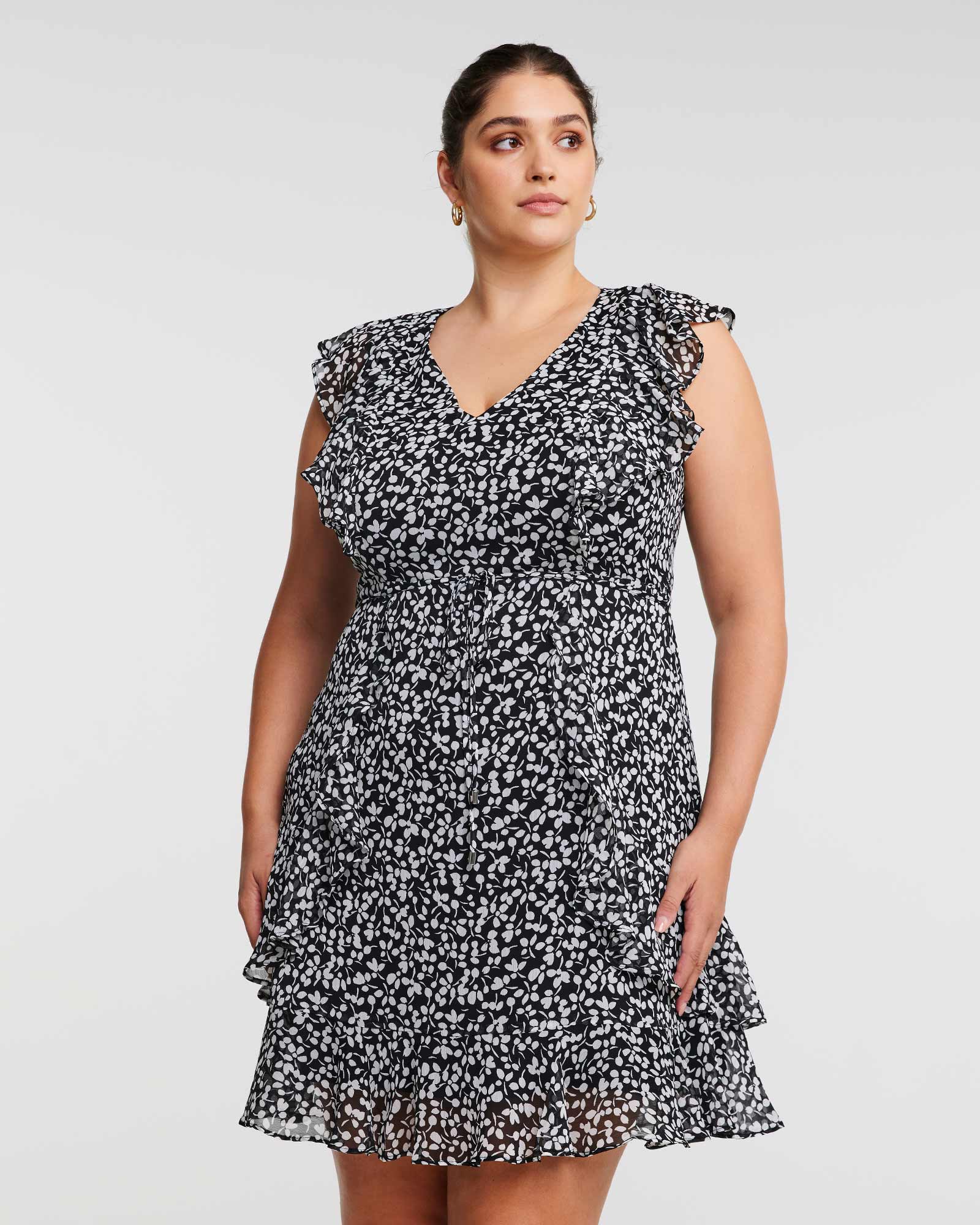 A plus size woman wearing the Olivia Black and White Ruffle Mini Dress.
