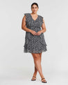 A plus size woman wearing the Olivia Black and White Ruffle Mini Dress in black and white leopard print.