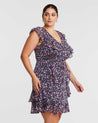 A plus size woman wearing the Estelle Rosebud Pink Mini Ruffle Dress.