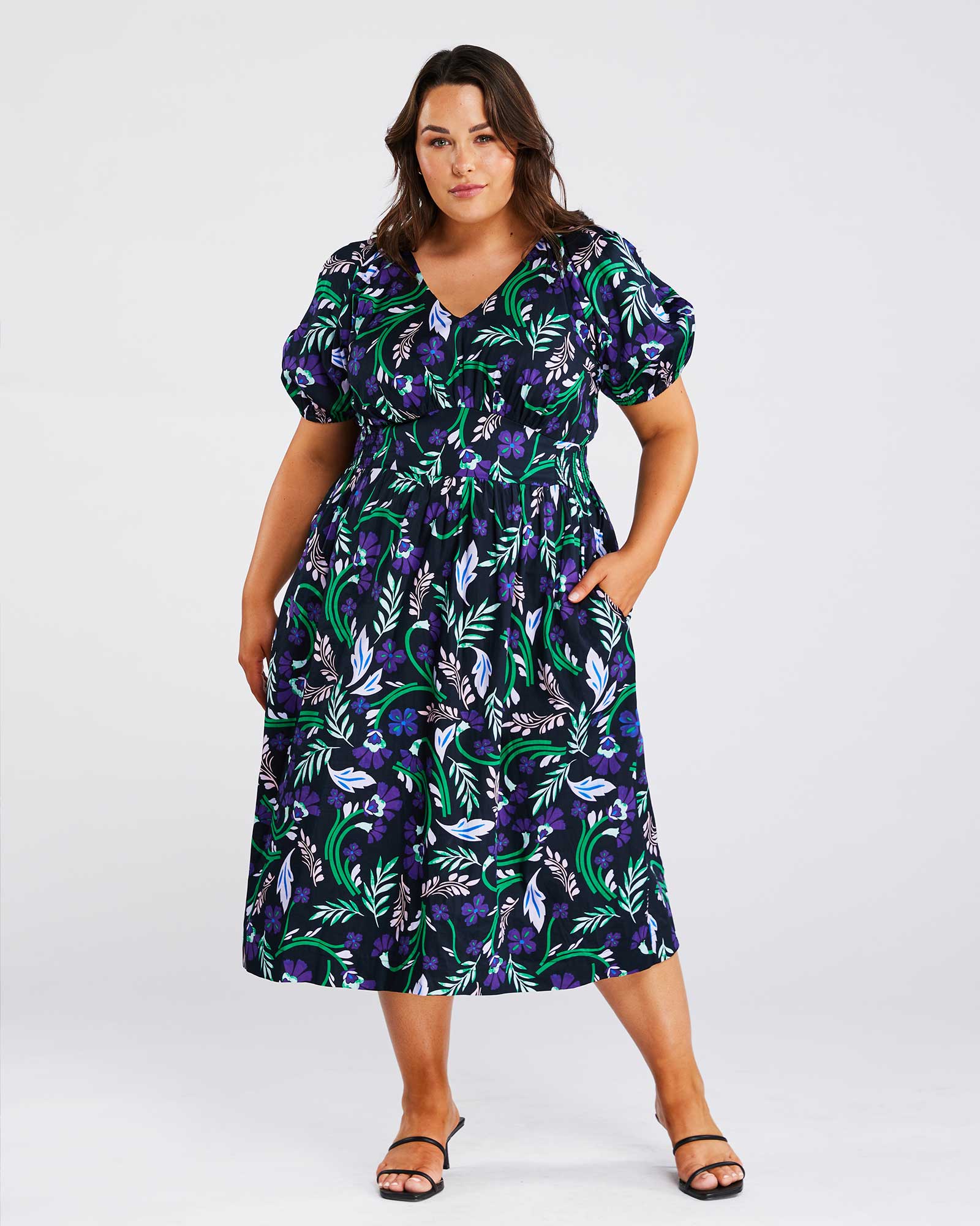 A plus-size fashionista wearing an Ultraviolet Cotton Floral Midi Dress.