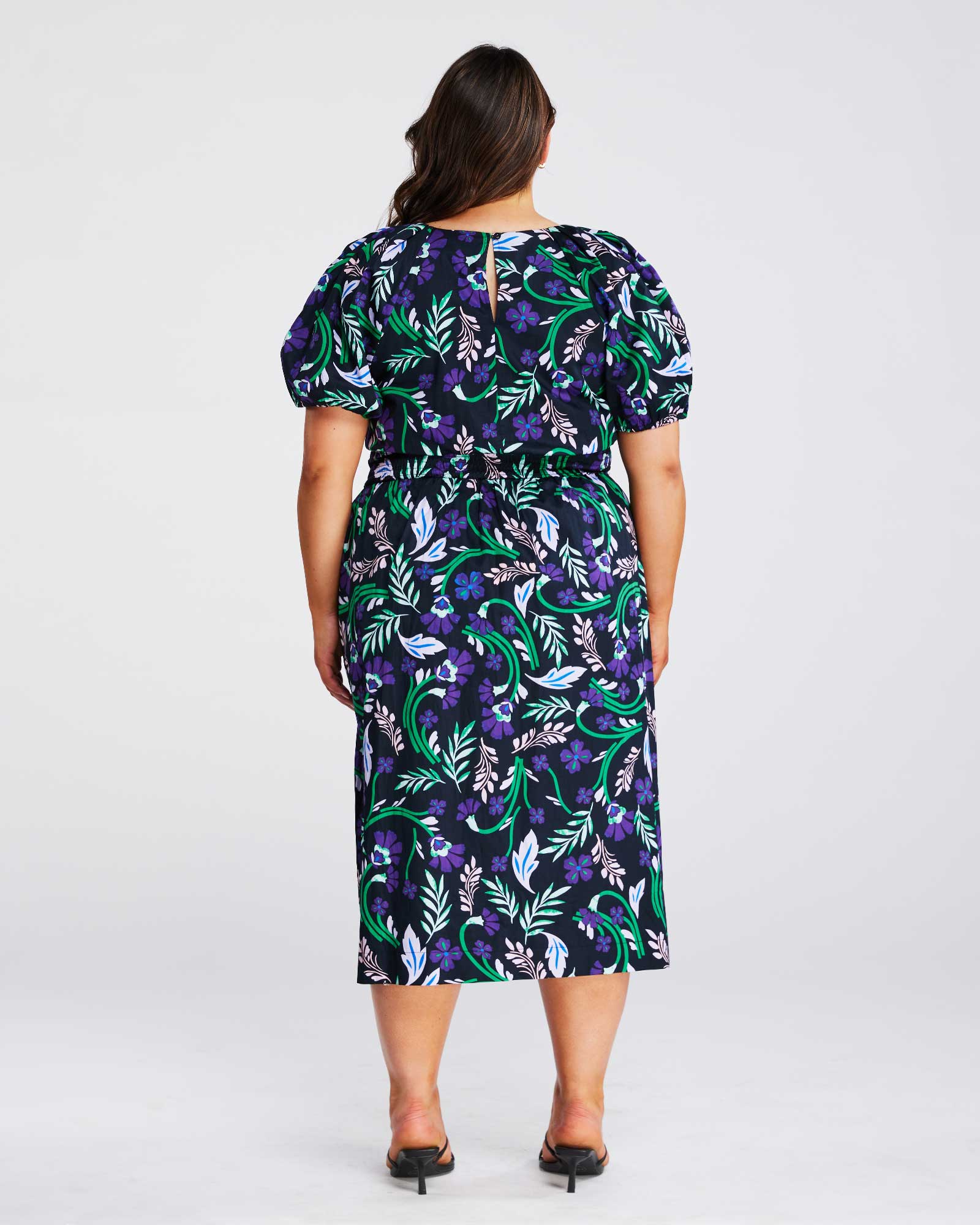 The back view of a plus size woman wearing an Ultraviolet Cotton Floral Midi Dress.