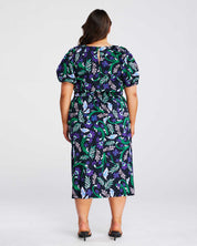 The back view of a plus size woman wearing an Ultraviolet Cotton Floral Midi Dress.