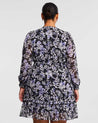 The back view of a woman in the Estelle Wild Orchid Long Sleeved Floral Dress.