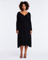 A plus-sized woman showcasing the versatility of the Florentine Black Long Sleeve Midi Knit Dress.
