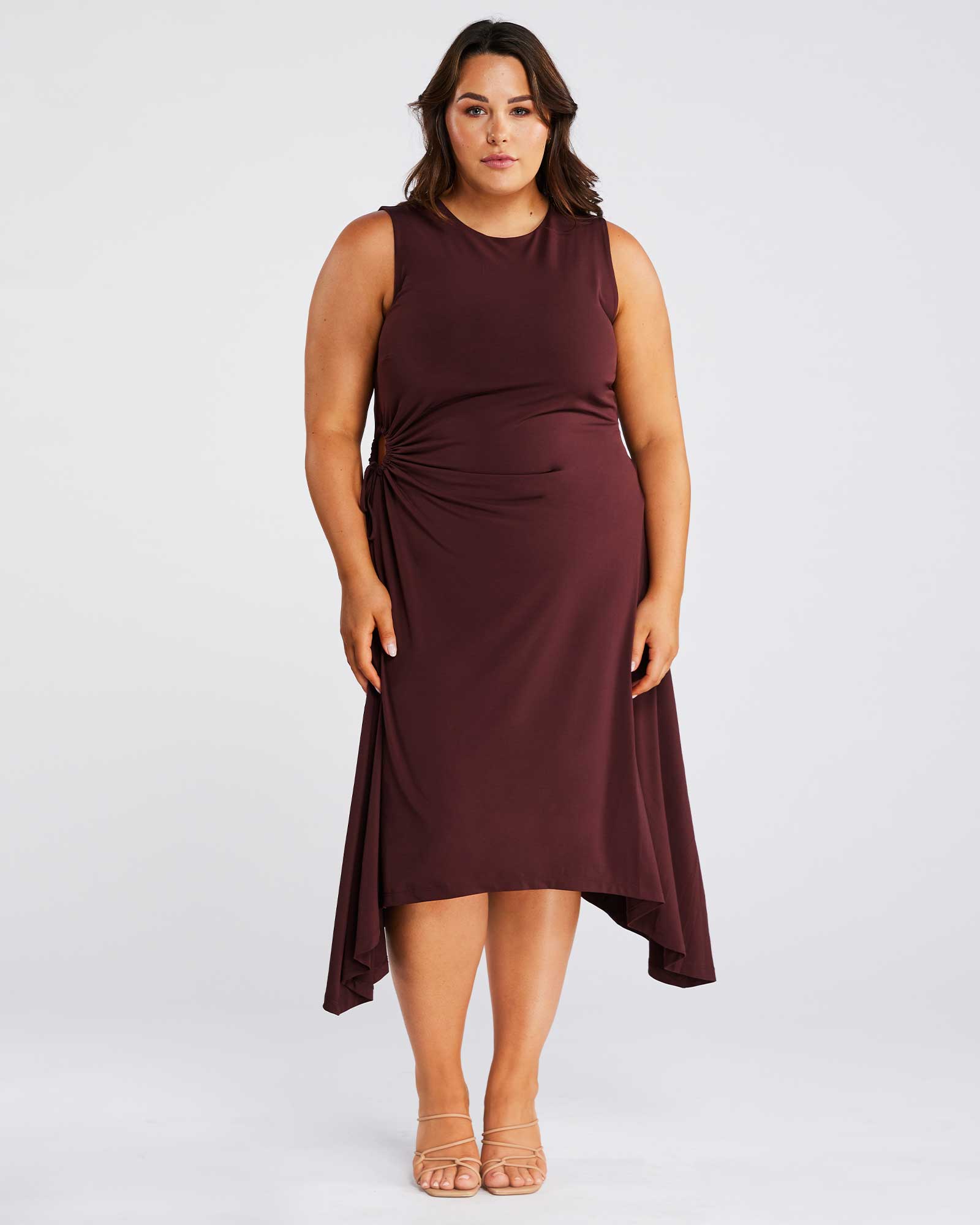 A plus size woman wearing an Estelle-us Yvette Dress in burgundy.