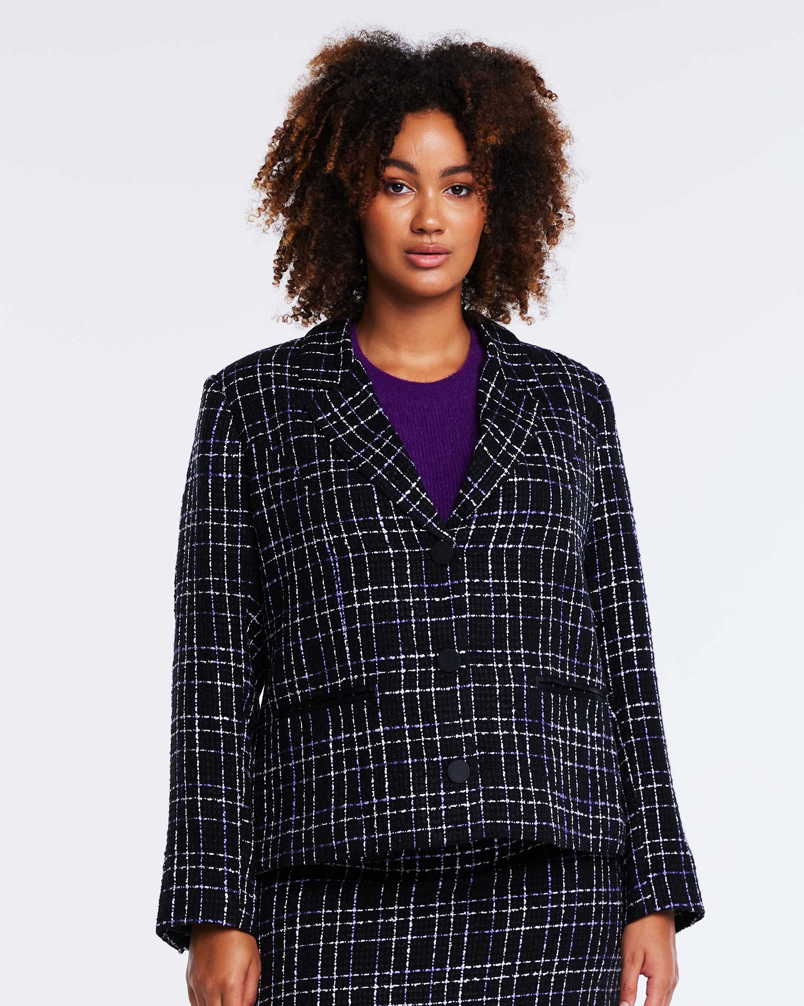 A woman wearing an Estelle Paris Tweed Blazer Jacket in black and purple plaid.