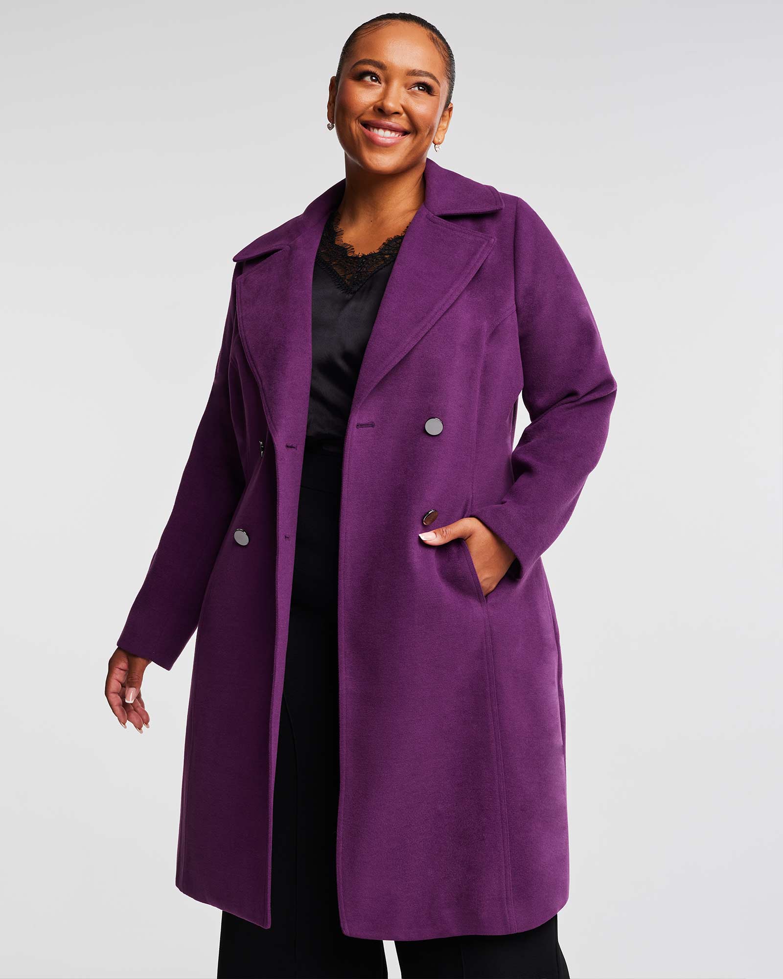 A woman wearing the Estelle Violet Sky Double Breasted Coat and black pants.