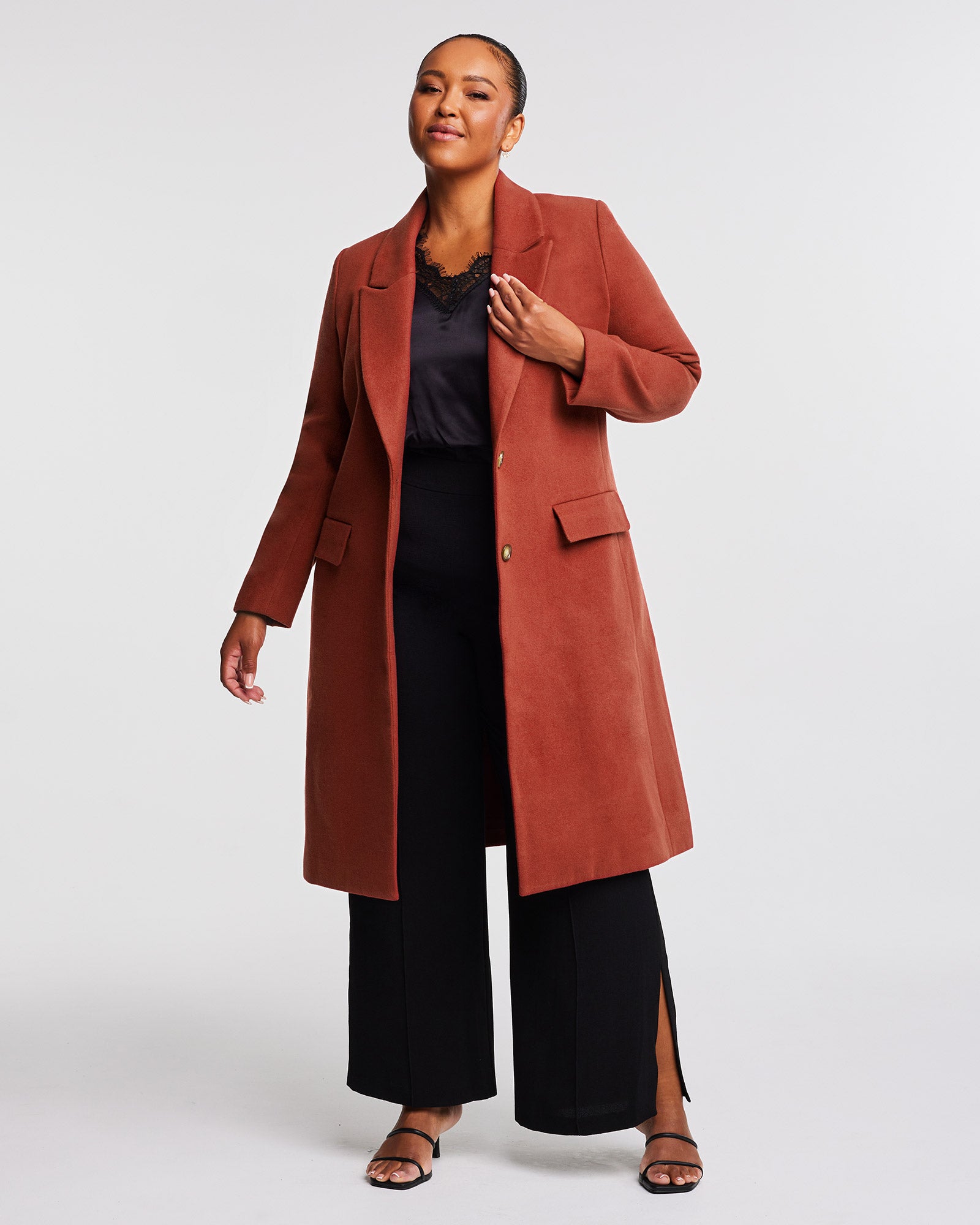 A plus-sized woman wearing a Mia Rust Full-Length Coat.