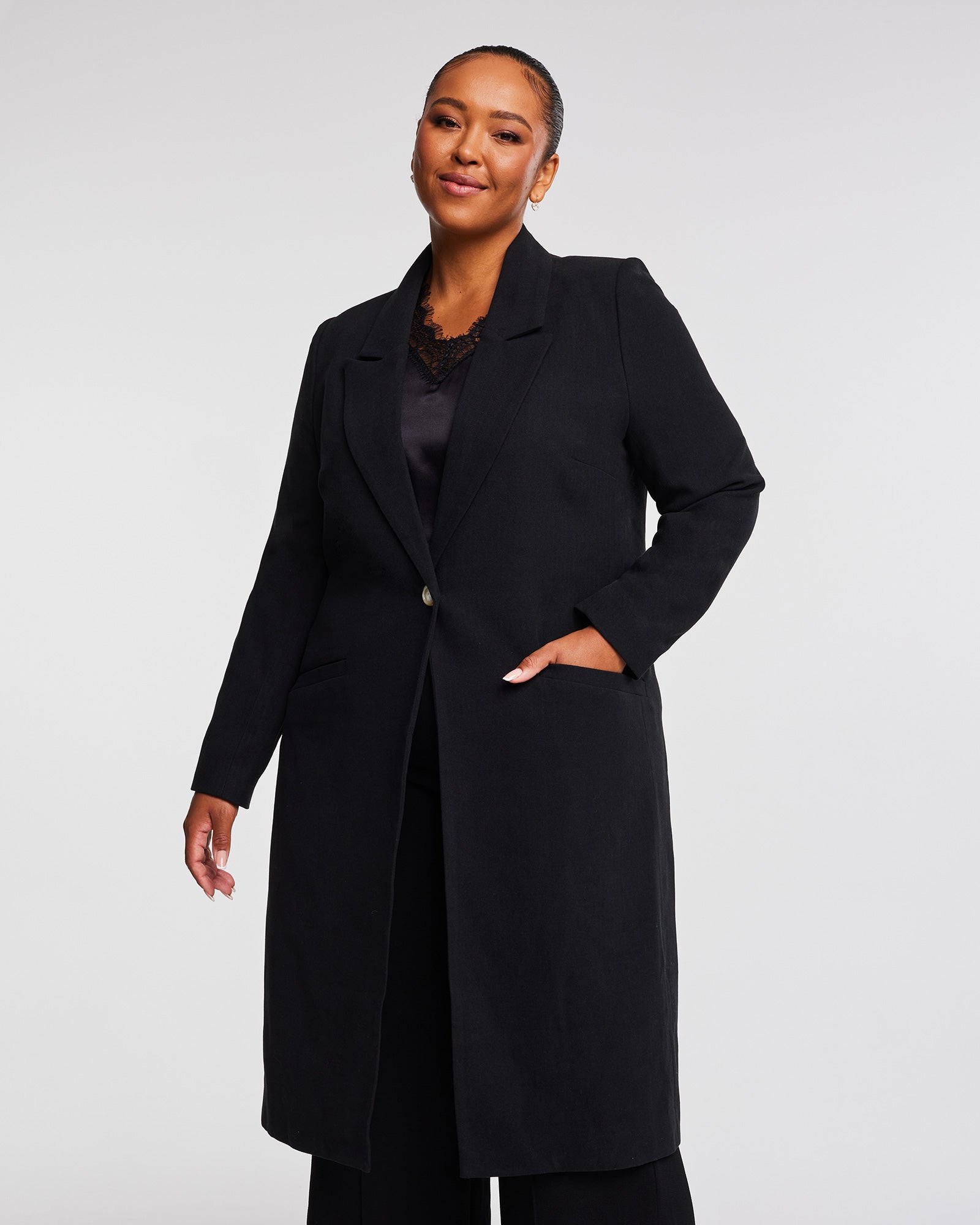 A plus-sized woman wearing a Long Line Black Full-Length Coat.