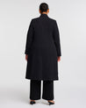 The back view of a plus-sized woman wearing a Long Line Black Full-Length Coat.