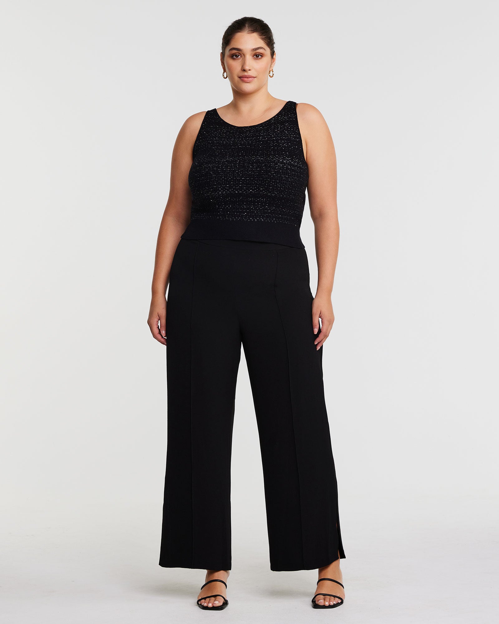 A plus size woman wearing black wide leg pants and an Abbey Knit Top.