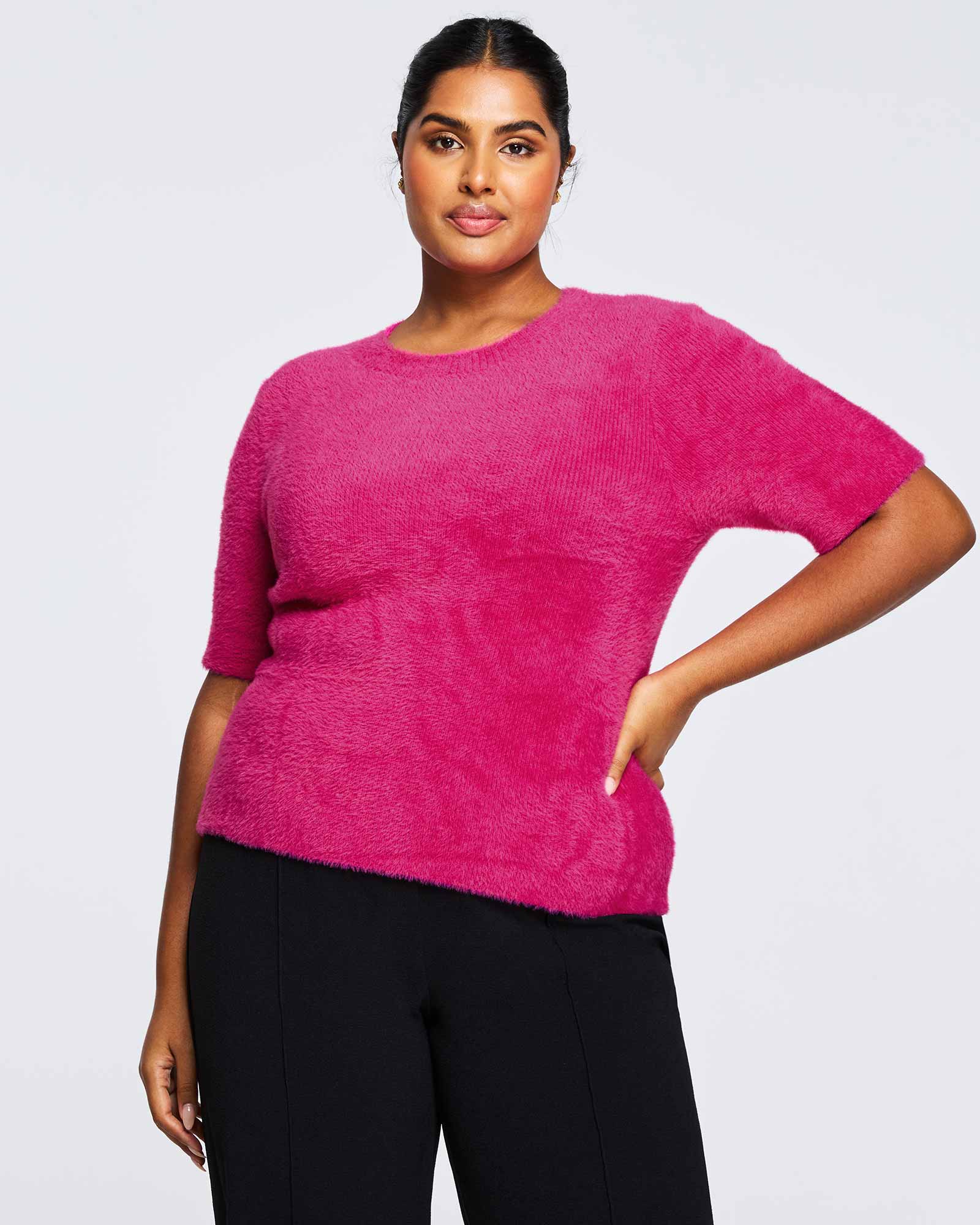 A comfortable plus-size woman wearing the Nora Fuzzy Pink Short Sleeved Sweater.