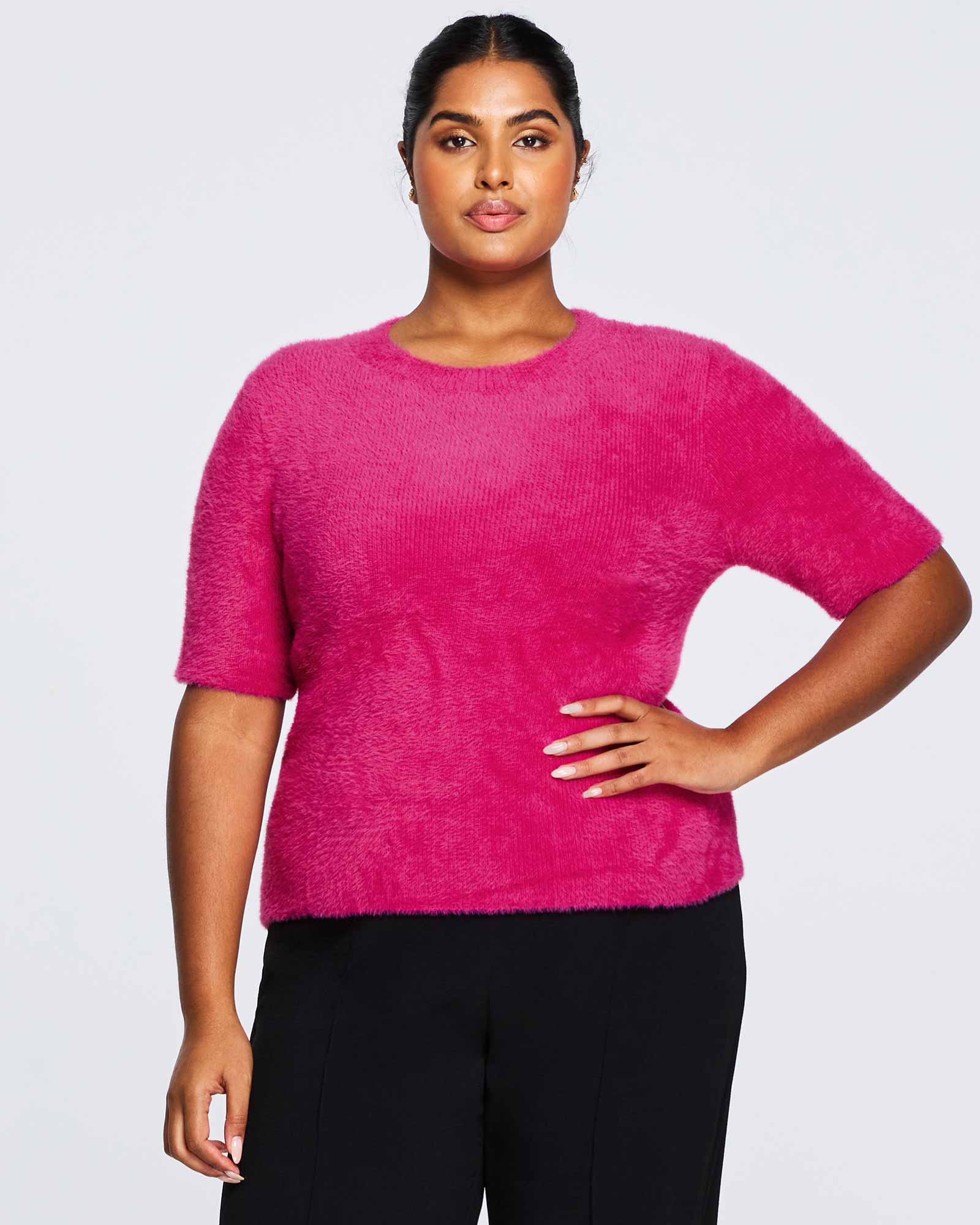 A plus-size woman wearing a Nora Fuzzy Pink Short Sleeved Sweater.