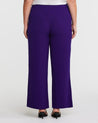 The back view of a woman wearing Nightlife Purple Wide Leg Pants made of textured polyester fabric.