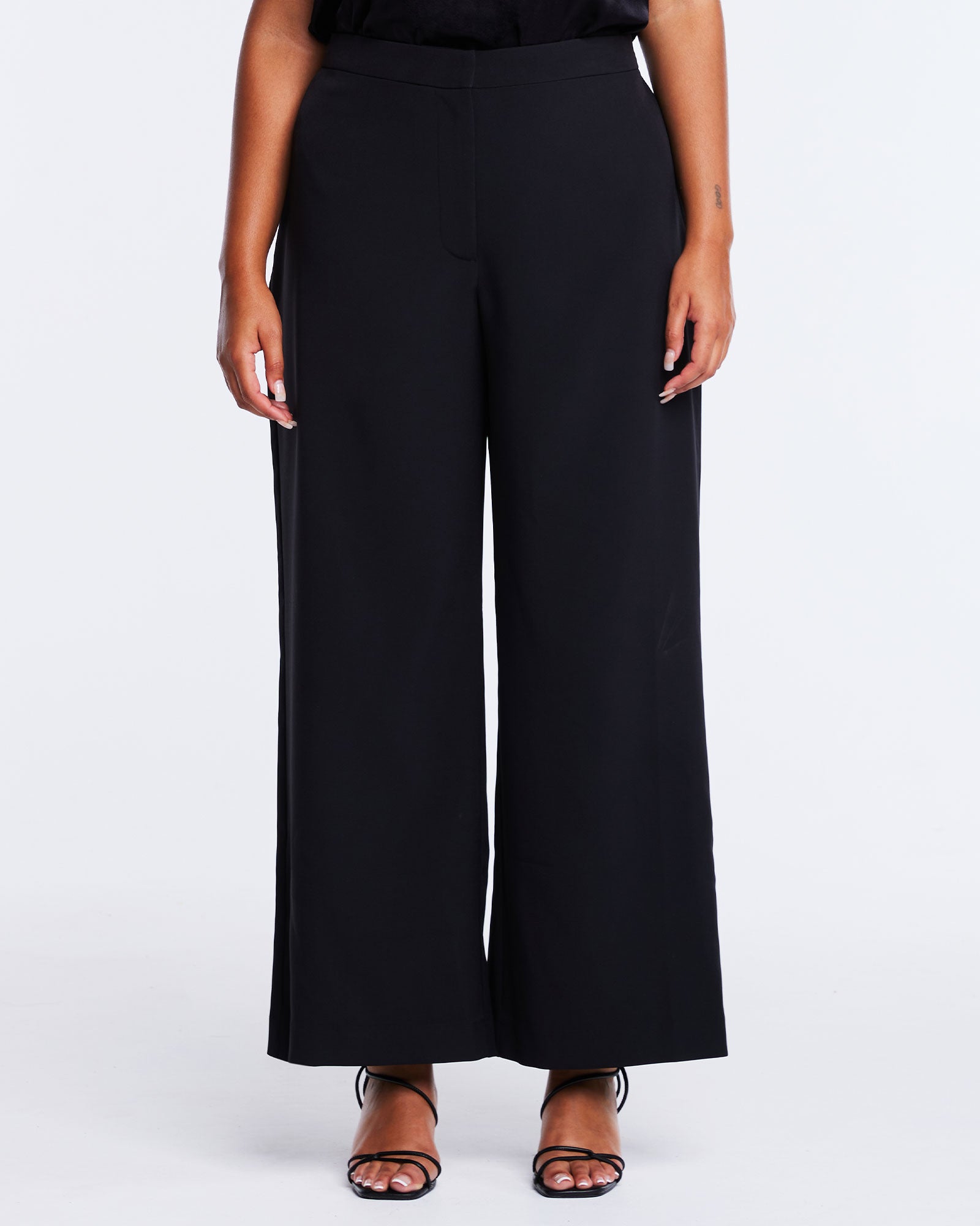 A plus-sized woman wearing the Savannah Black Wide-Leg Pant to elevate her capsule wardrobe.