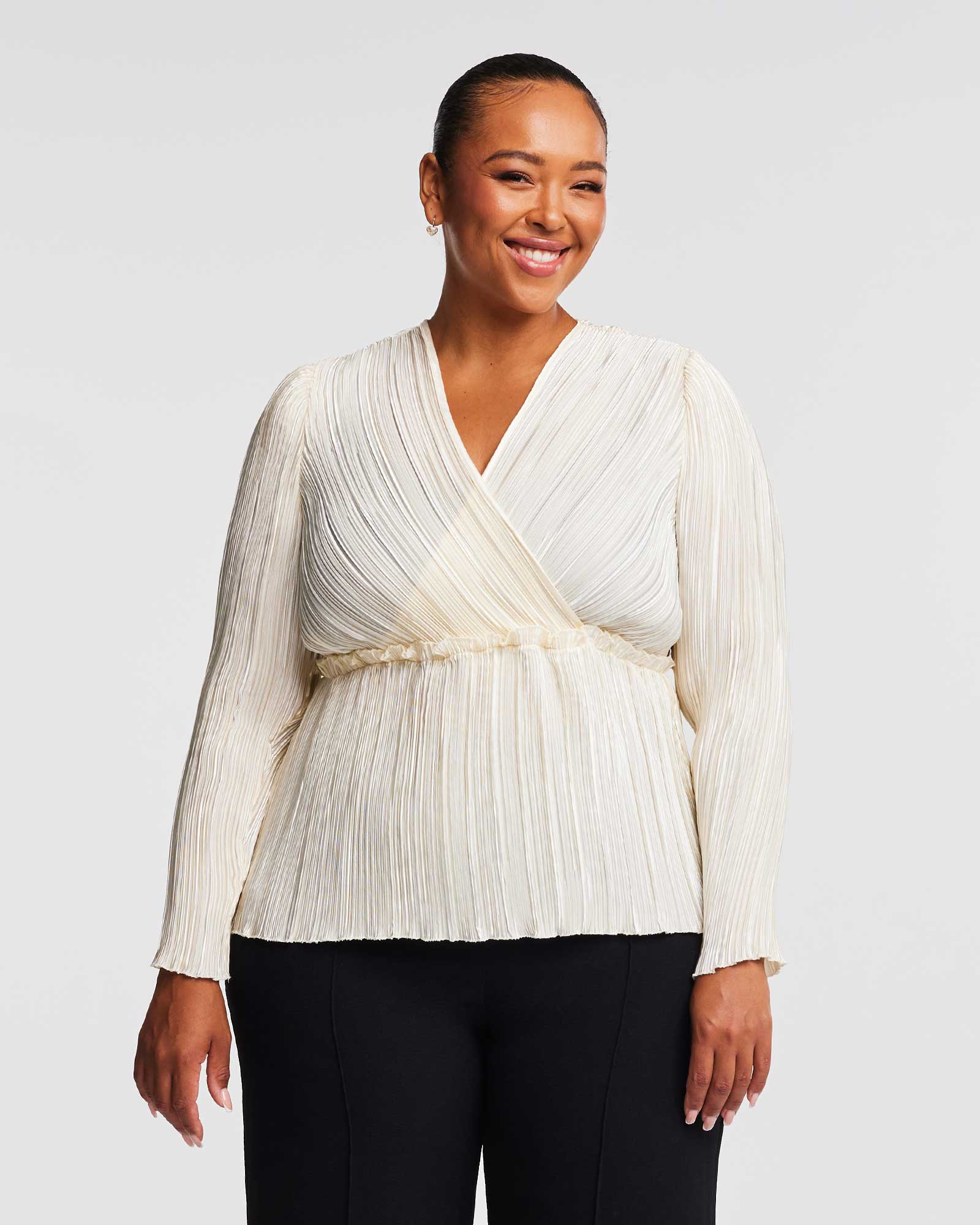 A versatile woman wearing the Alexandra Cream Wrap-Illusion Pleated Top.